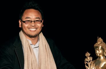 Headmaster Yeshi Tenzin with a golden Buddha